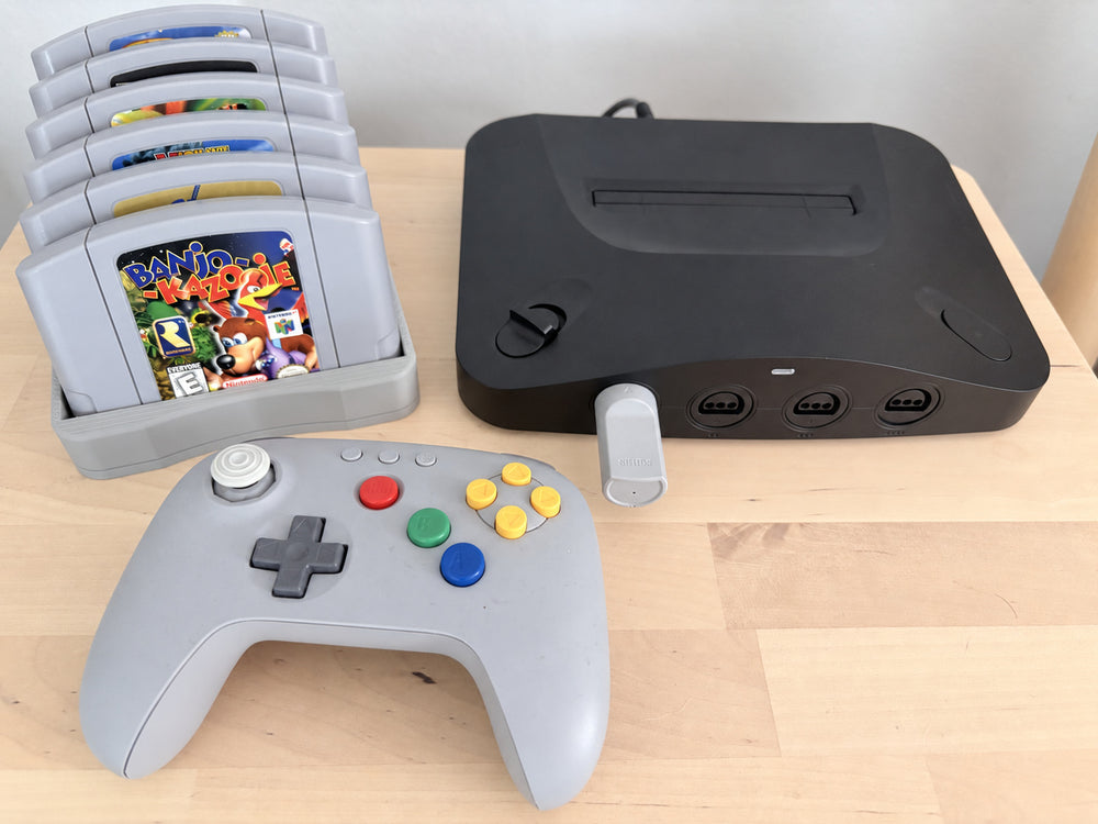 Our gray 3D-printed N64 holder beside a Nintendo 64 and controller in a real gaming setup