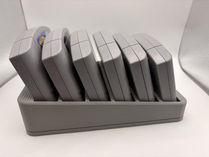 Side view of six Nintendo 64 cartridges leaning backward in the gray display holder.