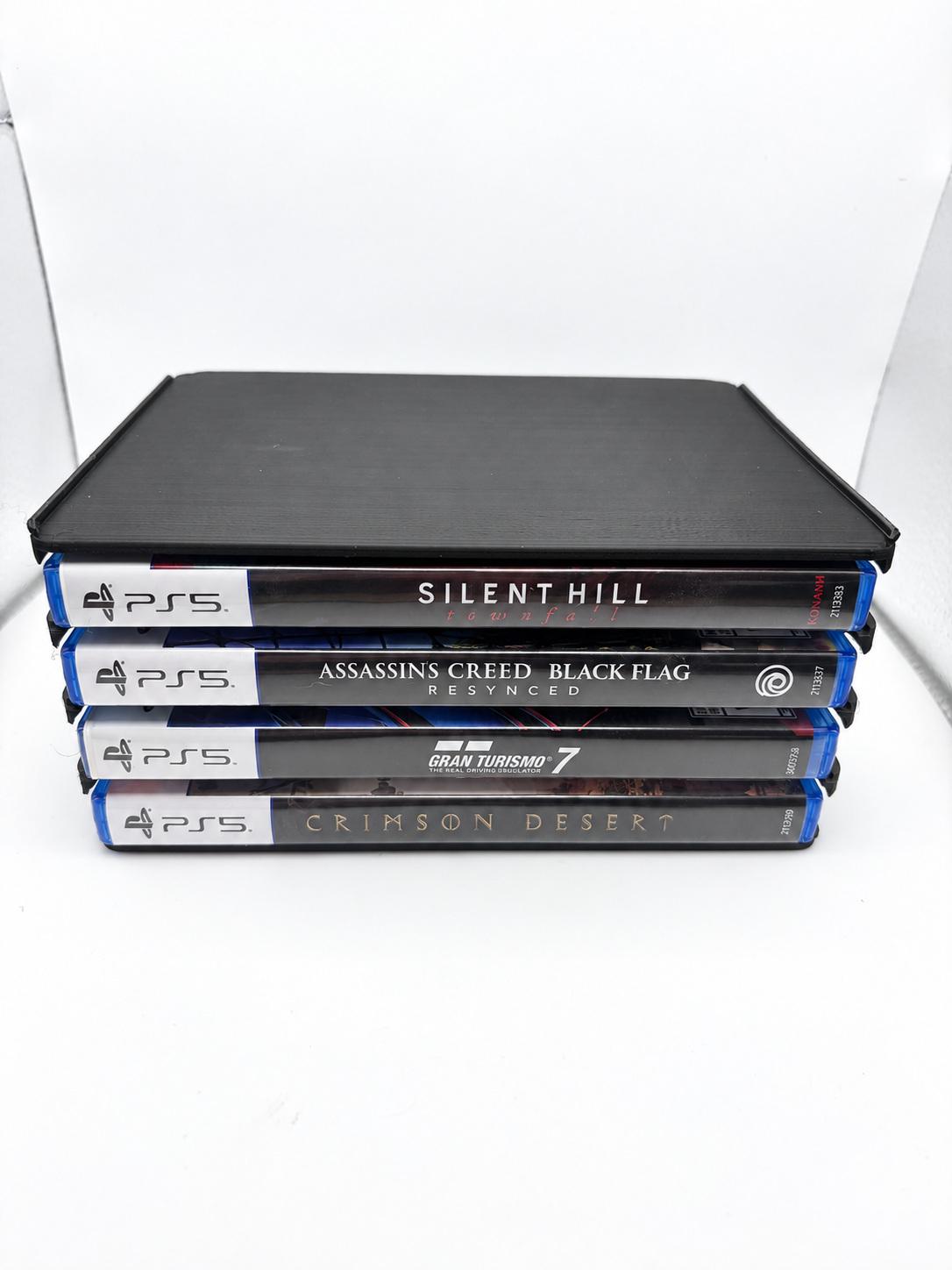 One black four-slot holder with four PS5 cases stored horizontally, spines facing forward.