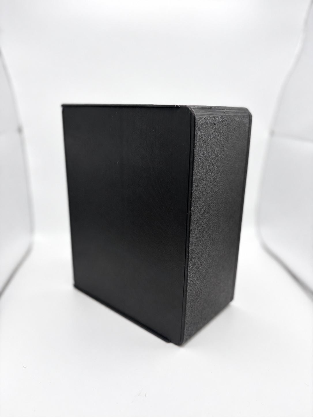 Empty black holder at an angle showing its enclosed side and rear panels and the actual printed finish.